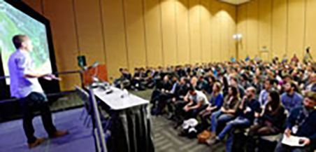Speakers podium that is empty in front of a crowd of people.